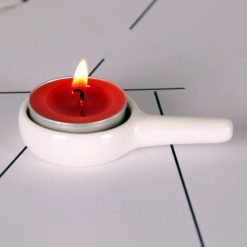 White ceramic tea light candle holder with a burning candle by Garden of Alice