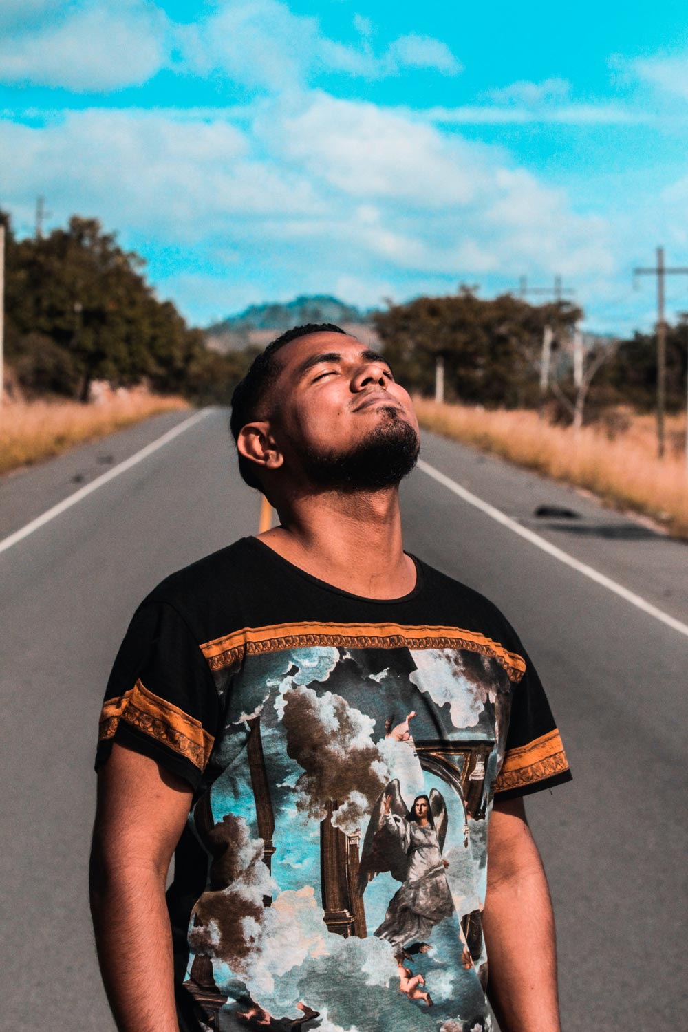 Latin man looking at the sky with the eyes closed on a street
